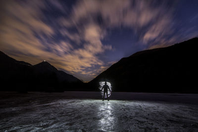 Scenic view of lake by mountain against sky during winter