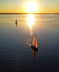 Sailboat on sea against sky during sunset