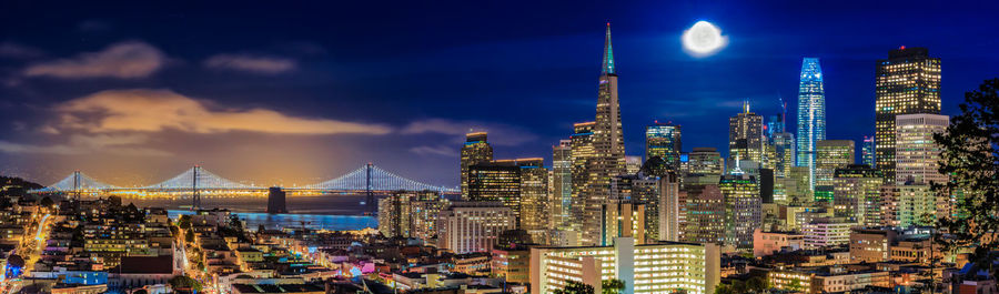 Illuminated cityscape against sky at night