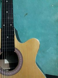High angle view of guitar against blue wall
