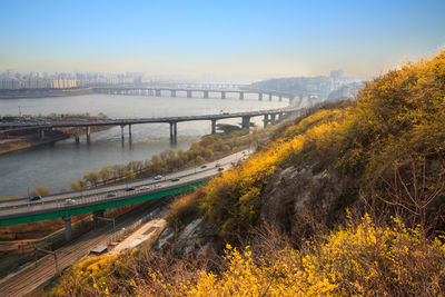 Bridge over river in city against sky