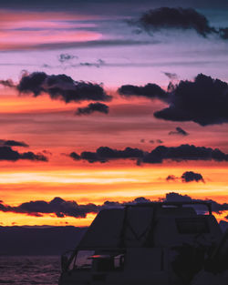 Scenic view of sea against dramatic sky during sunset