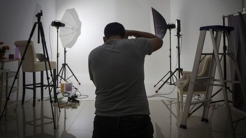 Rear view of man photographing in studio