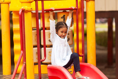 Thoughtful girl on slide at playground