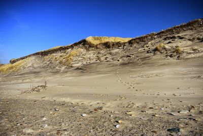 Scenic view of desert against clear blue sky