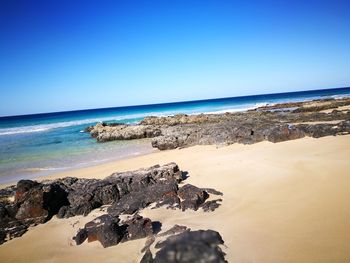 Scenic view of sea against clear blue sky