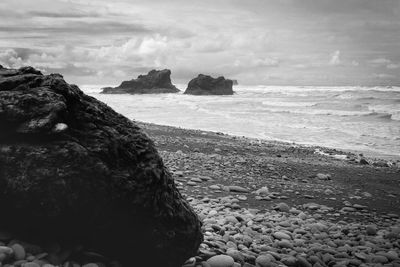 Rocks on beach against sky