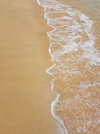 High angle view of waves rushing towards shore