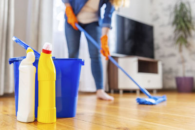 Low section of woman cleaning equipment