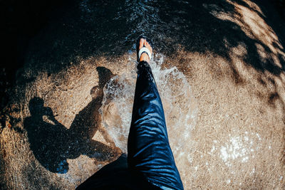 Low section of person with shadow on water