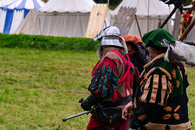 People in traditional clothes standing on field