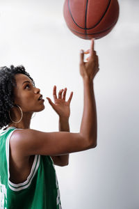 Portrait of a beautiful black women wearing basketball jersey holding basketball