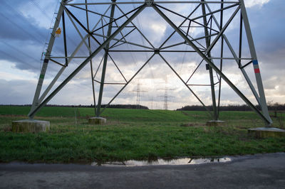 Electricity pylon on field against sky