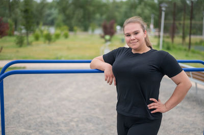 Portrait of beautiful young woman standing against blurred background