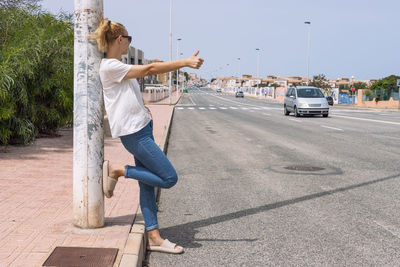 Full length of woman standing on road