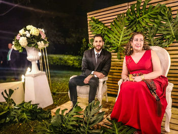 Portrait of a smiling young couple sitting on plants