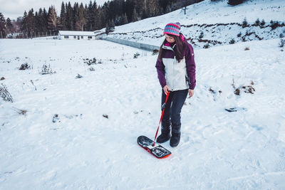 Full length of woman snowboarding on snow