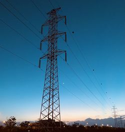 Low angle view of silhouette electricity pylon against clear sky