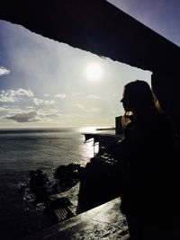 Woman looking at sea during sunset