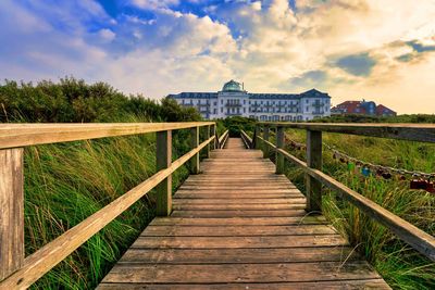 Wooden bridge over water against sky