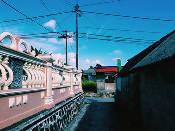 Road amidst buildings in city against sky