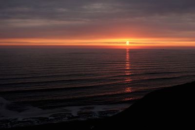 Scenic view of sea against orange sky