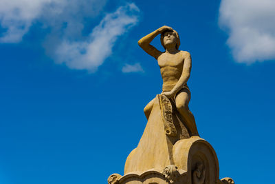 Low angle view of statue against blue sky