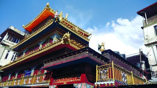 Low angle view of temple against cloudy sky