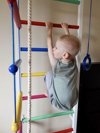 Boy goes in for sports on a ladder, home work out