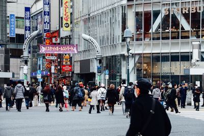 People walking on road along buildings