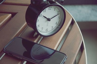 Close-up of alarm clock and mobile phone on the table