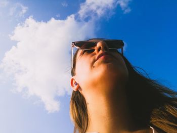 Low angle view of woman wearing sunglasses against sky