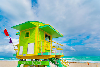 Lifeguard hut on beach against sky