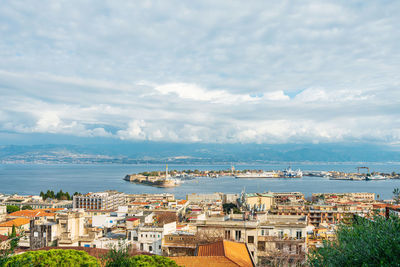 High angle view of townscape by sea against sky