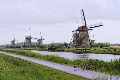 Traditional windmill on landscape against sky