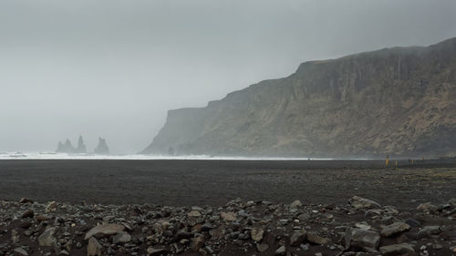 Scenic view of sea and mountains against sky