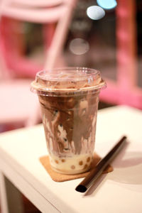 Close-up of iced coffee and drinking straw on table