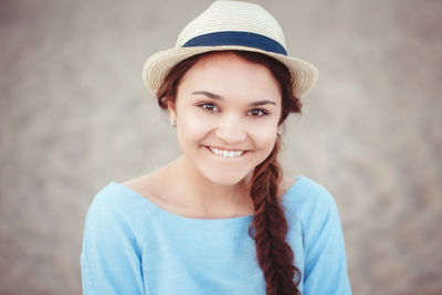 Close-up portrait of woman wearing hat at beach