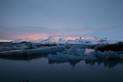 Scenic view of frozen lake against sky during sunset