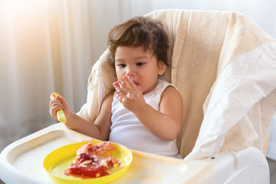 Portrait of cute girl eating food at home