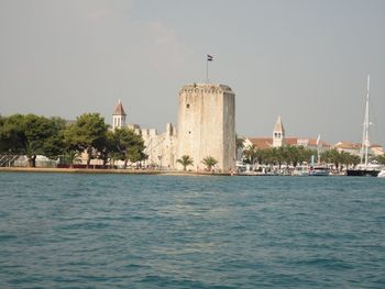 View of sea and buildings against clear sky