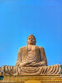 Low angle view of statue against blue sky