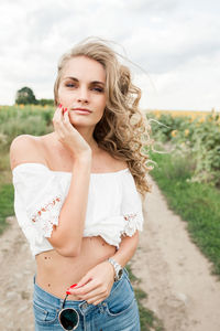 Portrait of young woman standing on field