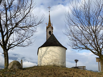 Low angle view of cross and trees against sky