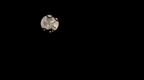 Low angle view of moon against black sky