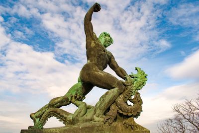 Low angle view of textured statue against sky