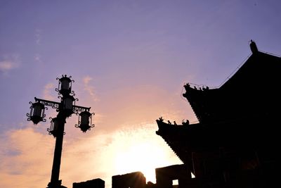 Low angle view of silhouette built structure against sky at sunset