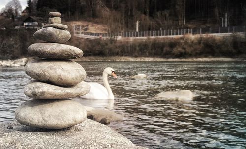 Stack of stones on rock by lake