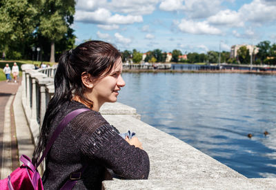 Young woman sitting on riverbank