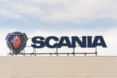 Low angle view of sign on wall against sky